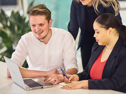 Drie collega's kijkend naar een laptopscherm