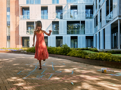 Meisjes aan het hinkelen voor een appartementencomplex