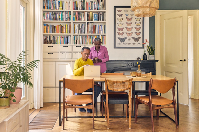 Echtpaar Man Zittend Vrouw Staand Eetkamer Eettafel Laptop 665X436