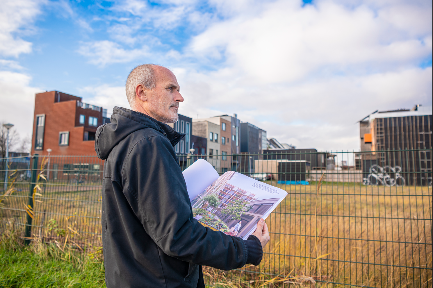 Edwin Oostmeijer met het plan van Transformatieproject Poppies en op de achtergrond gebouwen