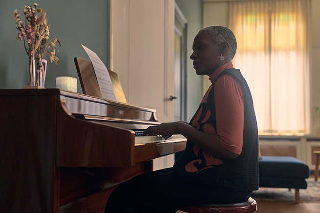 Vrouw die zittend achter de piano aan het spelen is